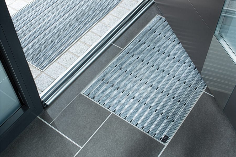 Ansicht einer Türschwelle mit einer Aluprofilmatte, welche in den Boden eingelassen wurde.