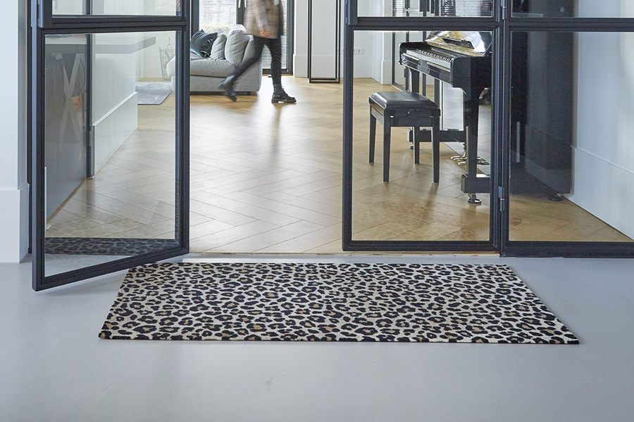 Ein moderner Wohnbereich mit geöffneter Loft-Tür. Vor der Tür liegt ein weicher Teppichläufer in Leopardenmuster.