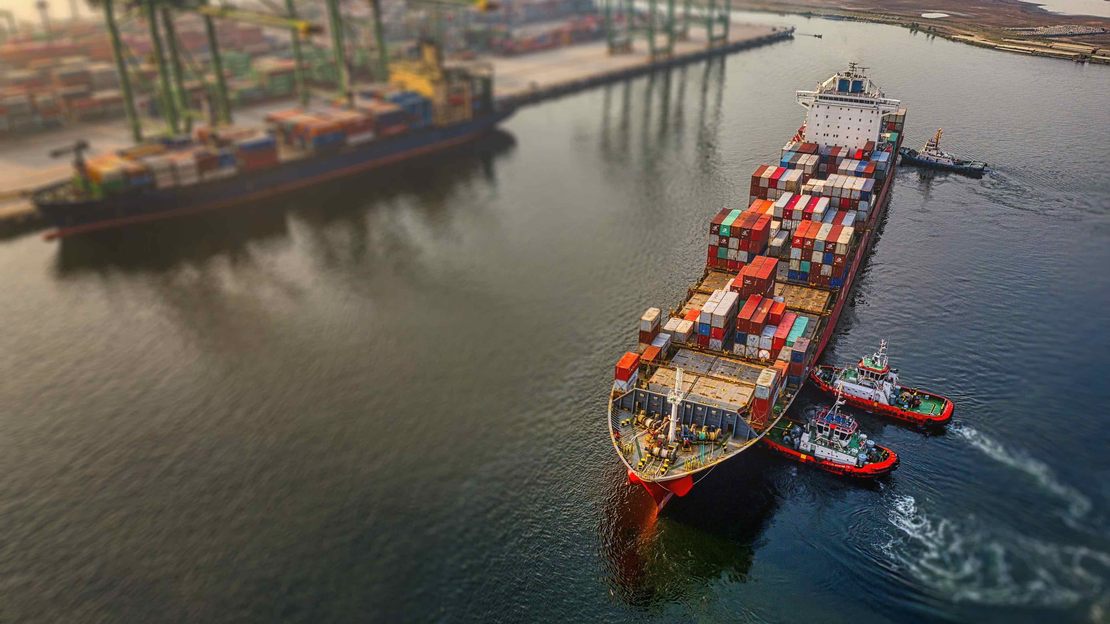 Güterschiff wird von Schleppboten an den Güterhafen gedrückt