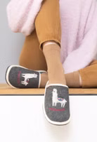 AdelheidPantoffel ✓ Weltenbummlerin Motiv ✓ made in Portugal ✓ Wollfilz mit Recycling-Anteil ein Paar dunkelgraue Filzpantoffeln mit süßer Lama-Applikation und darunter pinker Schriftzug "Weltenbummlerin". Außen hell eingefasst
