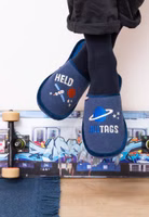 Adelheid Alltagsheld Filzpantoffel ✓ made in Portugal ✓ bequem ✓ echter Wollfilz baumelnd ein dunkelblaues Paar Filzpantoffeln mit großem Schriftzug Alltagsheld und Weltraummotive in weiß, blau und orange sowie dunkelblauer Einfassung