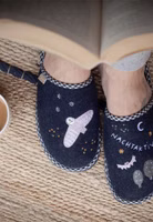 ein dunkelblaues Paar Filzpantoffeln von oben mit der Stickerei einer rosa Eule, grauer Bäume, rosa Fledermaus, Mond und dem Schriftzug Nachtaktiv, vichy-karo-schwarze Einfassung