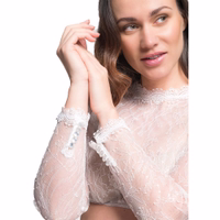 Ärmeldetailansicht der Dorina-Dirndlbluse am Modell, mit zarten Spitzenärmeln, durchgehendem Muster und feinen Glitzerdetails – langärmelige Dirndlbluse, entworfen für Oktoberfest und traditionelle Trachtenmode.