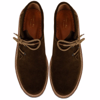 Here’s the German translation:  **Diese traditionellen bayerischen Schuhe in Dunkelbraun präsentieren ein elegantes Design mit Seitenschnürung und verbinden klassischen Stil mit Praktikabilität. Für sicheren Halt und außergewöhnlichen Komfort gefertigt, bi